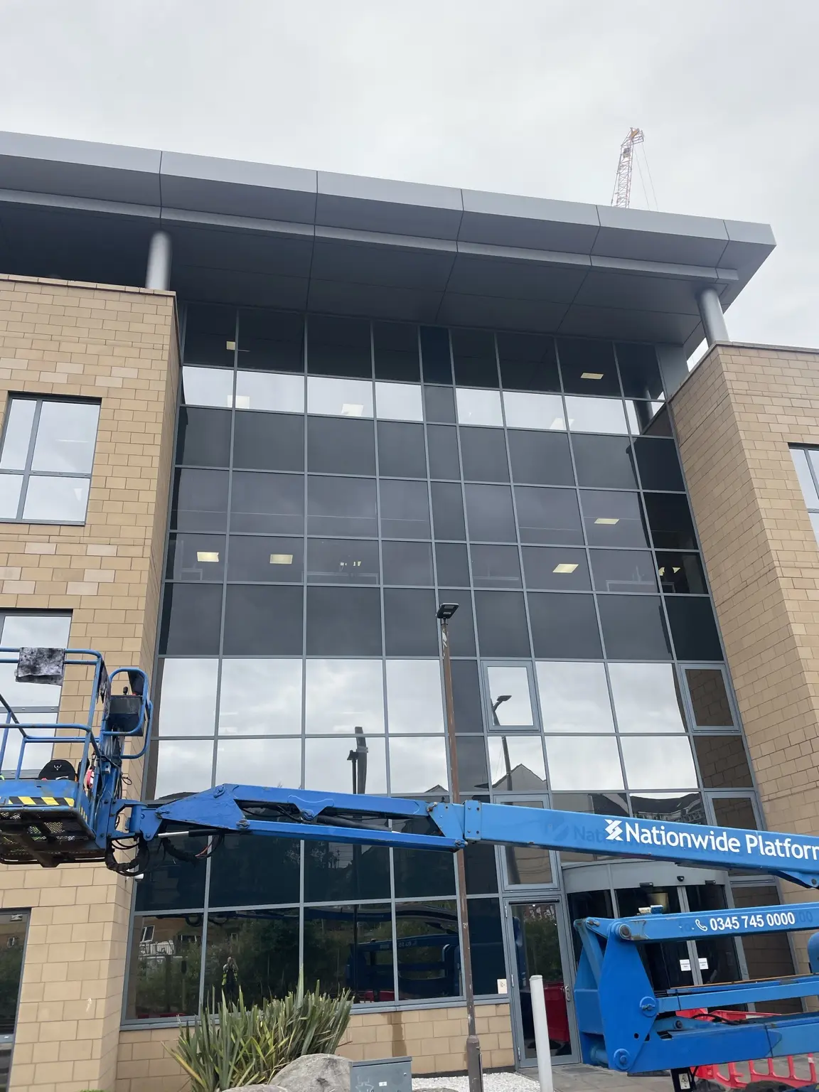 Commercial glazing installation in progress using specialist access equipment